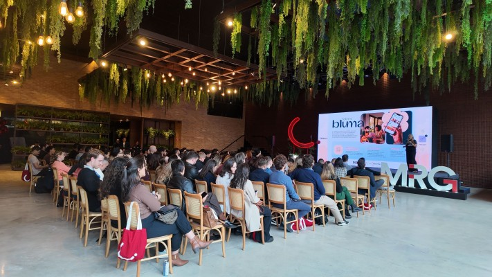 Plateia do evento MRG, com a apresentação no telão ao fundo. Foto: divulgação MRG.